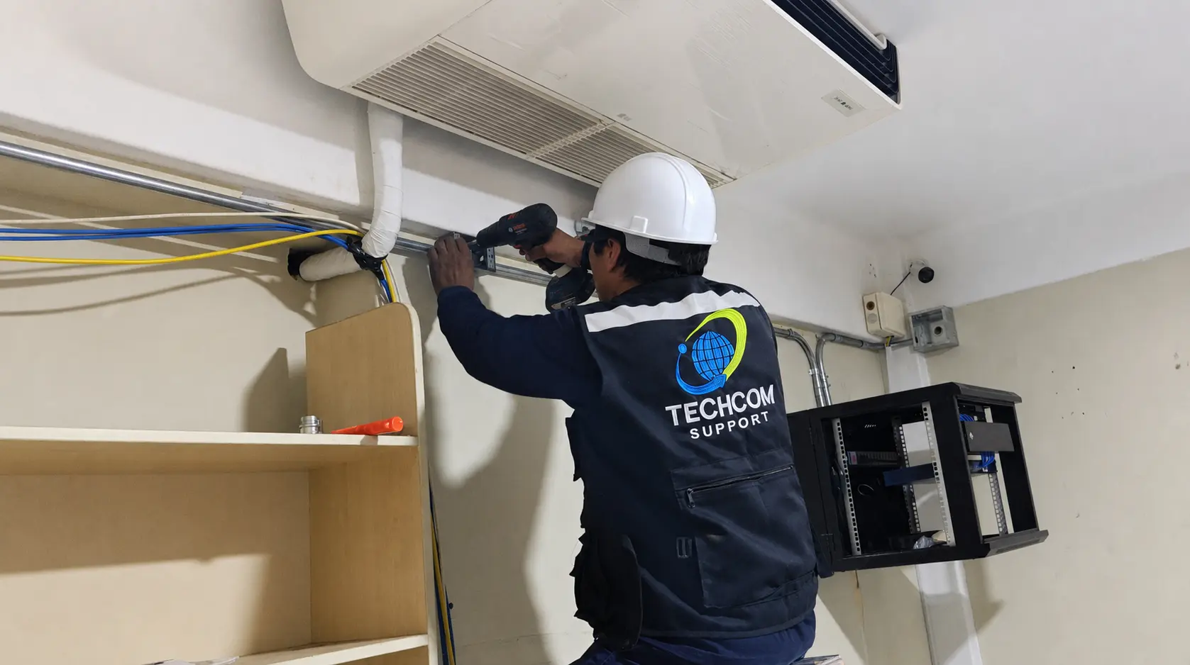 Técnico de TECHCOM instalando un gabinete de comunicaciones